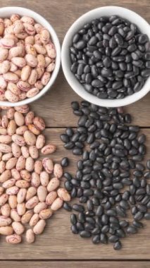 Tahta masanın üzerinde beyaz kâselerin üzerinde çeşitli fasulyelerin yakın plan çekimi..