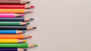 Açık kahverengi arkaplan üzerinde renkli kalemler kopyalama alanı ile.