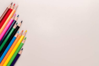 Açık kahverengi arkaplan üzerinde renkli kalemler kopyalama alanı ile.