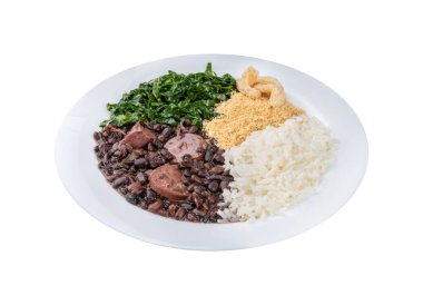 Beyaz arka planda pirinç, farofa, lahana ve çıtırtılarla izole edilmiş tipik Brezilya feijoadası.