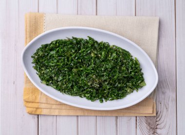Pişmiş lahana şeritleri, tipik Brezilya feijoada turpu ahşap masanın üzerinde bir kasede..