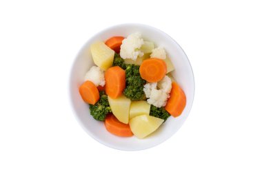 Beyaz arka planda izole edilmiş bir tabakta pişirilmiş sebzeler.