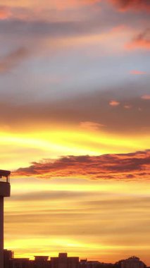 Büyük bir şehrin üzerindeki bulutlu bir günde gün doğumu