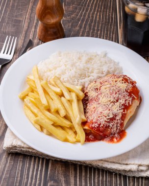 Parmegiana tavuk göğsü, pilav ve patates kızartması. Tipik Brezilya idari yemeği..