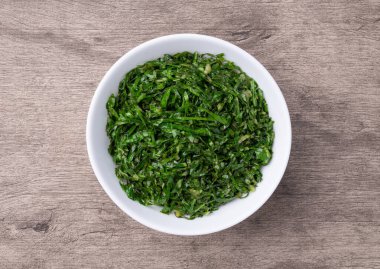 Pişmiş lahana şeritleri, tipik Brezilya feijoada turpu ahşap masanın üzerinde bir kasede..