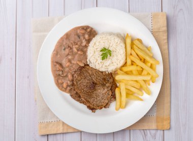 Biftek, pilav, fasulye ve patates kızartması. Tipik Brezilya idari yemeği..