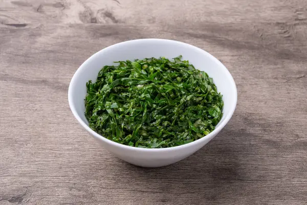 Pişmiş lahana şeritleri, tipik Brezilya feijoada turpu ahşap masanın üzerinde bir kasede..