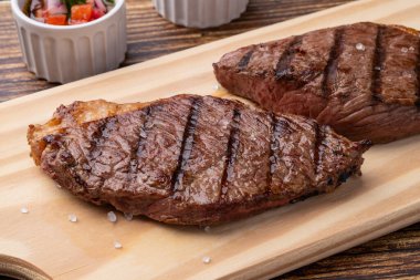 Tahta üstünde ızgara Picanha bifteği ve sirke sosu..