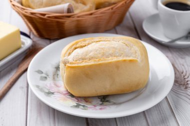 Beyaz ahşap masanın üzerinde tereyağlı ve kahveli Fransız ekmeği veya tuzlu ekmek..