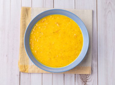 Balkabağı ve kurutulmuş et çorbası ahşap bir masada..