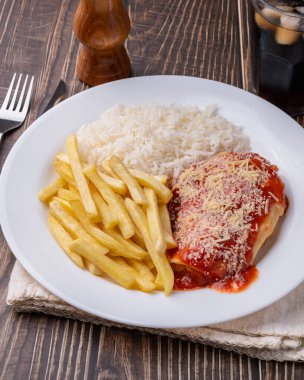 Parmegiana tavuk göğsü, pilav ve patates kızartması. Tipik Brezilya idari yemeği..