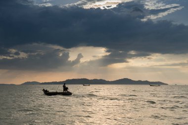 Filikadaki balıkçı suya yansıyor