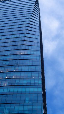 Uzun, modern bir binanın kısmi manzarası ve bulutlu bir gökyüzü