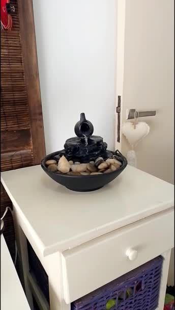 白い木製のテーブルの上に装飾的な禅の噴水の近くのビュー — ストック動画
