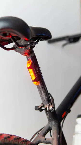Close view of a red safety light attached to a black bicycle
