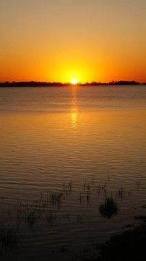 Landscape view of a beautiful sunset over Chascomus lake, Buenos Aires                                       clipart