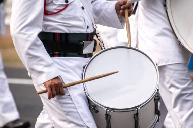 Gaydacı sopayla akustik davul çalıyor.