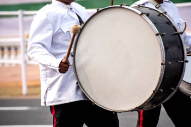 Gaydacı sopayla akustik davul çalıyor.