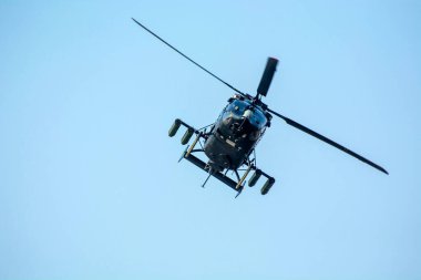 Savaş helikopteri izole edilmiş mavi gökyüzüne doğru uçuyor..