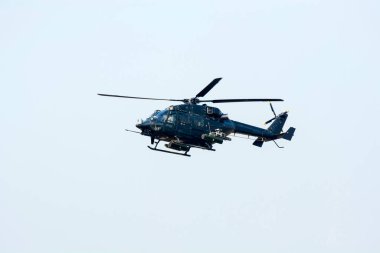 Savaş helikopteri düşmana saldırmaya hazırlanıyor. Helikopter izole edilmiş mavi gökyüzünde uçuyor.