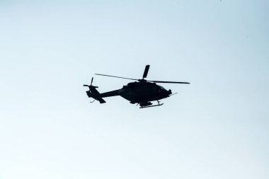 Siluet helikopter mavi gökyüzünde izole bir şekilde uçuyor. 