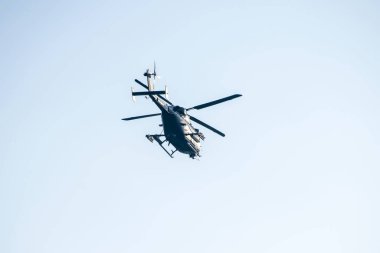 İzole edilmiş mavi gökyüzünde uçan bir helikopter.