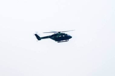 Siluet helikopter gökyüzünün ortasında uçuyor.