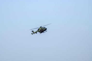 İzole edilmiş mavi gökyüzüne doğru uçan helikopter yaklaşıyor.