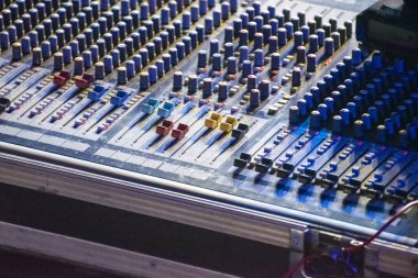 Ses mühendisi bir ses kaydı oluşturmak için karıştırma konsolu kullanıyor.