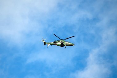 Helikopter arka planda, izole edilmiş mavi gökyüzünde uçuyor..