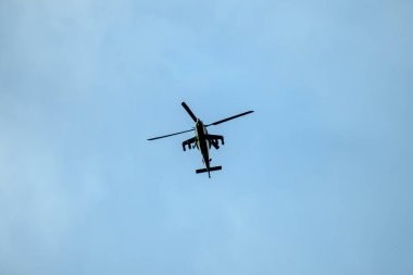 Helikopter arka planda, izole edilmiş mavi gökyüzünde uçuyor..
