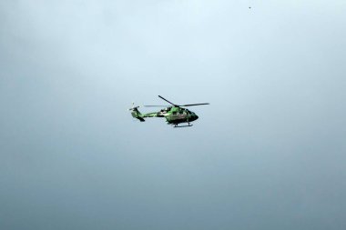Helikopter arka planda, izole edilmiş mavi gökyüzünde uçuyor..