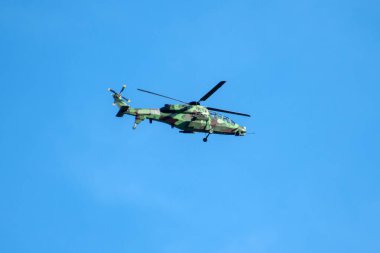 Helikopter arka planda, izole edilmiş mavi gökyüzünde uçuyor..