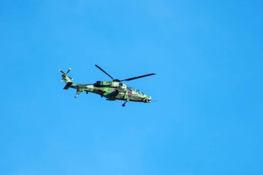 Helikopter arka planda, izole edilmiş mavi gökyüzünde uçuyor..