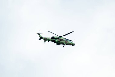 Helikopter arka planda, izole edilmiş mavi gökyüzünde uçuyor..