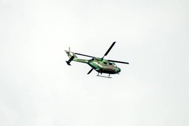 Helikopter arka planda, izole edilmiş mavi gökyüzünde uçuyor..