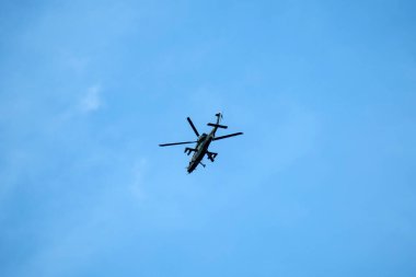 Helikopter arka planda, izole edilmiş mavi gökyüzünde uçuyor..