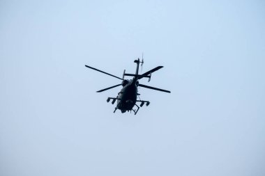 Helikopter arka planda, izole edilmiş mavi gökyüzünde uçuyor.