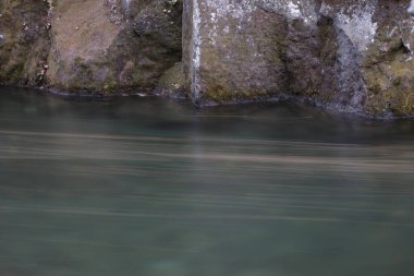 Kayalıkların dibinde akan uzun süreli nehir suyu.