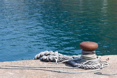 İskele kıyısında demir korkuluk ve ip.
