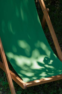 Boş yeşil bir bahçe sandalyesinde güneş ışığı.
