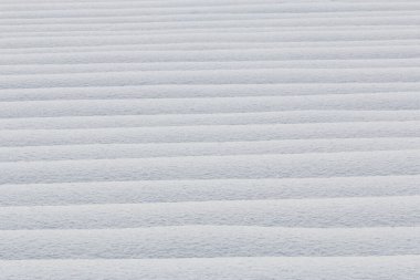 Japonya 'da kışın saf beyaz karın yatay arkaplanının soyut dokusu.