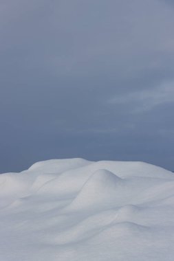 Lumpy beyaz kar yüzeyi ve mavi gökyüzü arkaplan