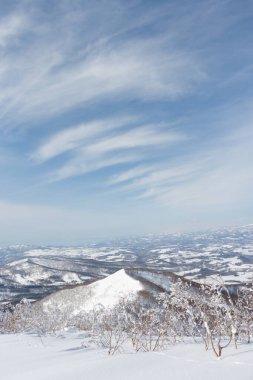 Rusutsu 'daki Japon kış manzarası üzerinde beyaz bulutlar ve mavi gökyüzü