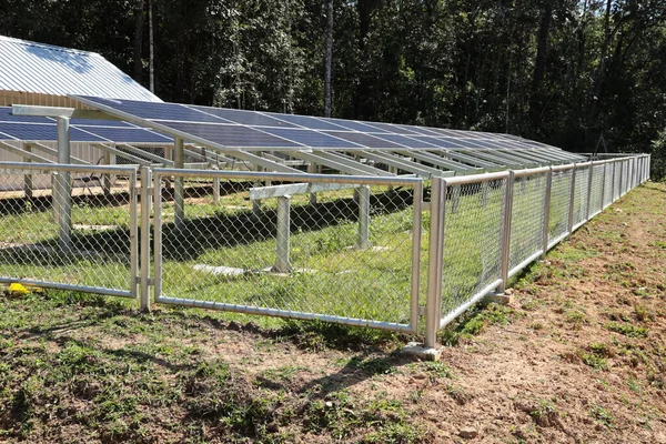 太阳能农场金属围栏 长金属链环围绕着太阳能电池板 以防止绿树背景上的电气危害 并提供复制空间 选择性重点 — 图库照片