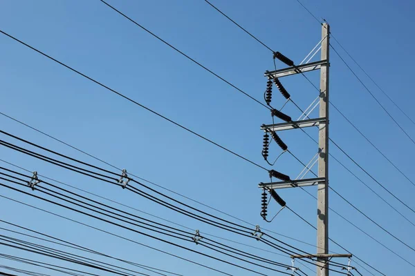 極に高電圧線を持つ電極 青い空の背景に都市分布のためのコンクリート極の金属腕の上に中断セラミック絶縁体との伝送ライン — ストック写真