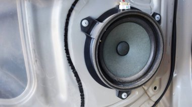 Arabanın kapısında kirli hoparlörler var. Garajın kapısına fotokopi alanı olan eski ve kirli hoparlörlerin yakın çekimleri. seçici odak