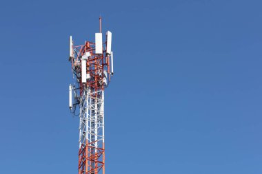 Mavi gökyüzüne karşı baz istasyonu. Kablosuz telefon sistemi 4G 'yi almak ve iletmek için iletişim kulesine yakın plan. Kopya uzayı olan açık mavi gökyüzü arkaplanı 5G. Seçici odak