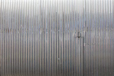 Gümüş çinko arka plan. Gümüş kıvrımlı metal duvar ya da kısmen yırtılmış galvanize çelik yüzey. Seçici odaklı arkaplan duvarı