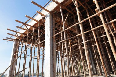 İnşaat için koltuk değnekleri. Bina, ikinci kattaki kiriş ve zemin inşaatındaki çimento ağırlığını desteklemek için bir sürü şiş kullanılarak inşa edildi. Seçici odak